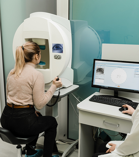 Woman having her eyes examined while optometrist uses a computer