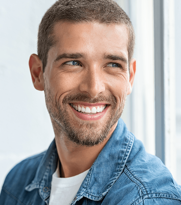 Bearded man in denim jacket smiling