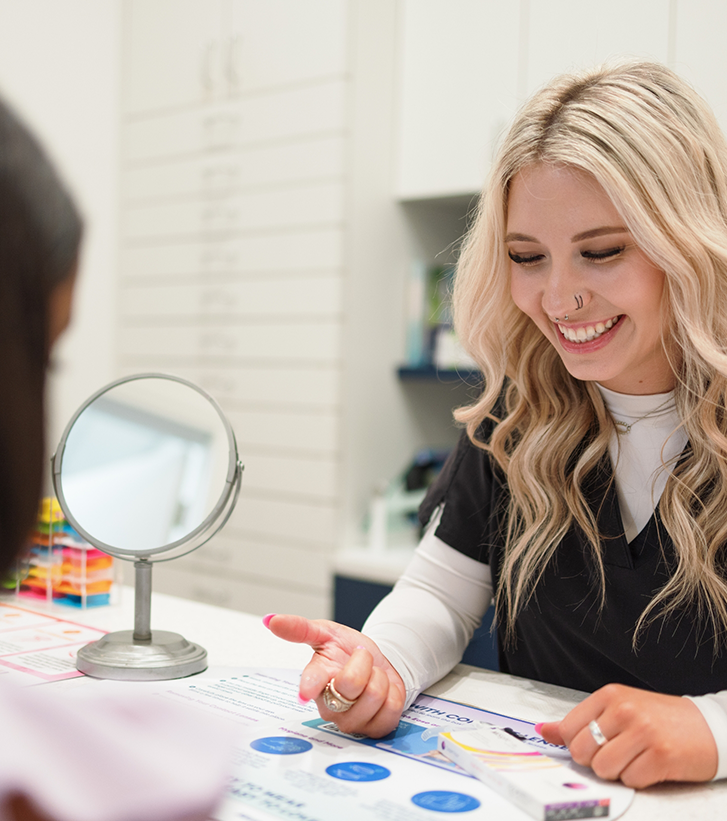 Optometry team member sitting across a table from a patient