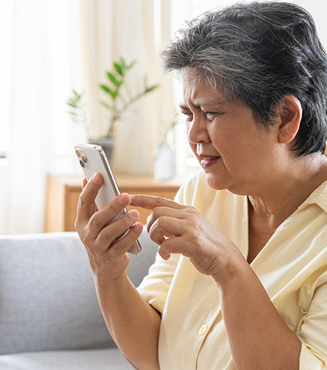 Woman squinting while trying to scroll on her phone