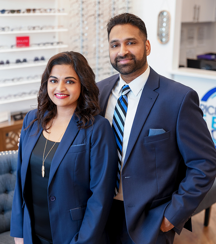 Doctor Chetti smiling with her husband Joe in formal attire in the optometry office